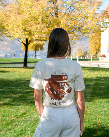 Person wearing a t-shirt with a bear graphic and text in an outdoor setting